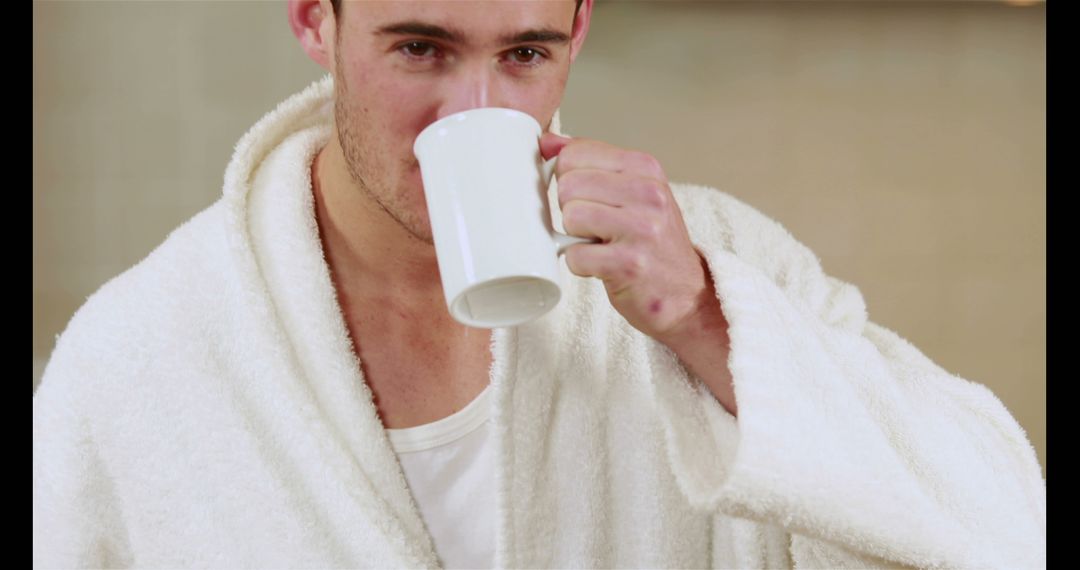 Man in White Bathrobe Drinking from Mug in Cozy Morning Routine - Free Images, Stock Photos and Pictures on Pikwizard.com