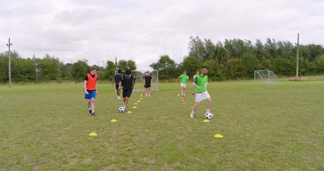 Teen Soccer Players Exercising Dribbling Skills on Grass Field