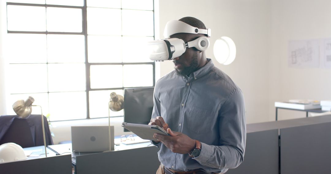 Man Using VR Headset and Tablet in Modern Office Setting for Innovation