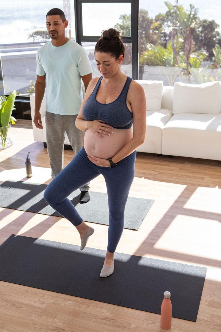 Pregnant Woman Practicing Yoga with Partner's Support at Home