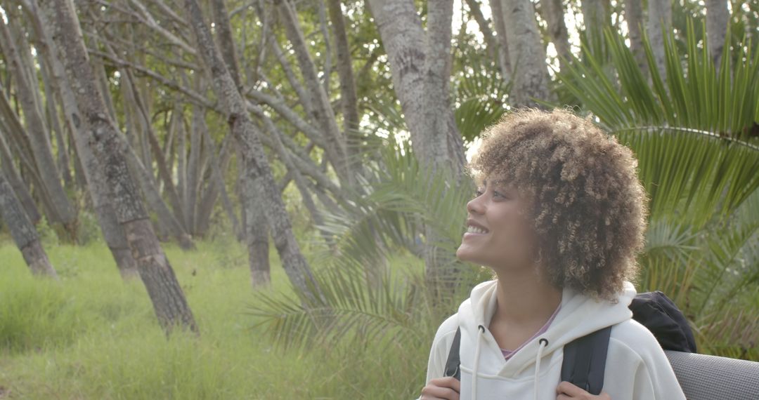 Smiling Young Woman Enjoying Nature Hike in Forest
