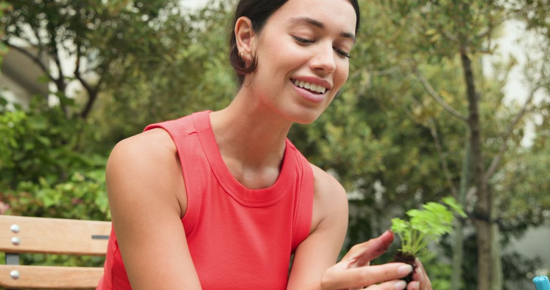 Woman Enjoying Gardening in Sunny Backyard with Seedling