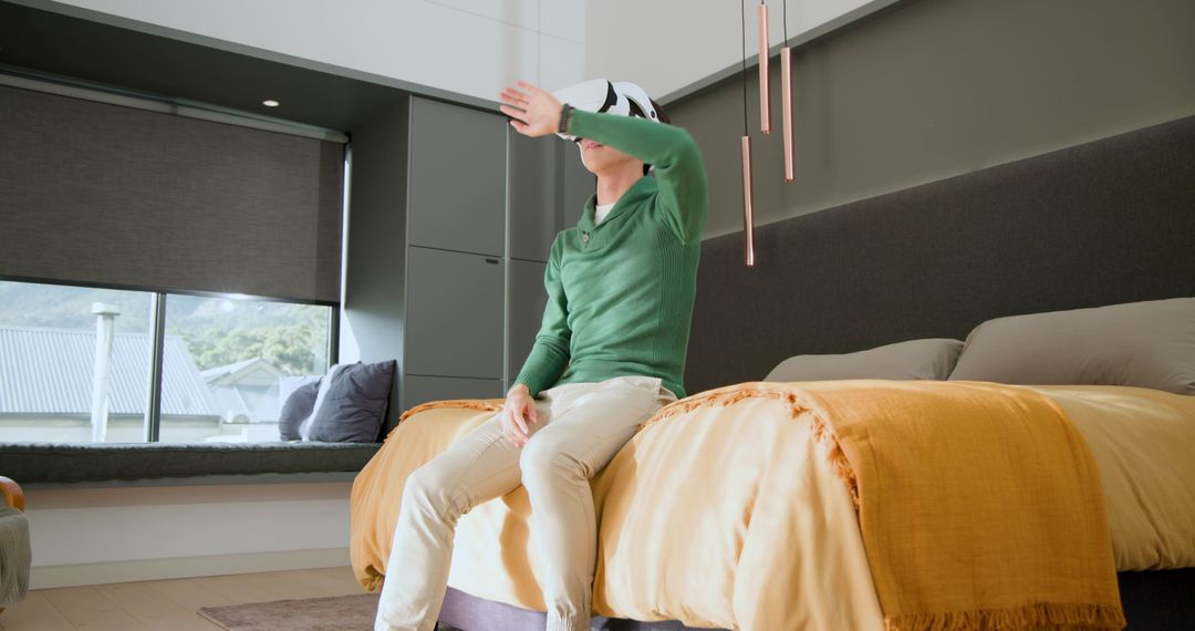 Man Experiencing Virtual Reality While Relaxing in Modern Bedroom