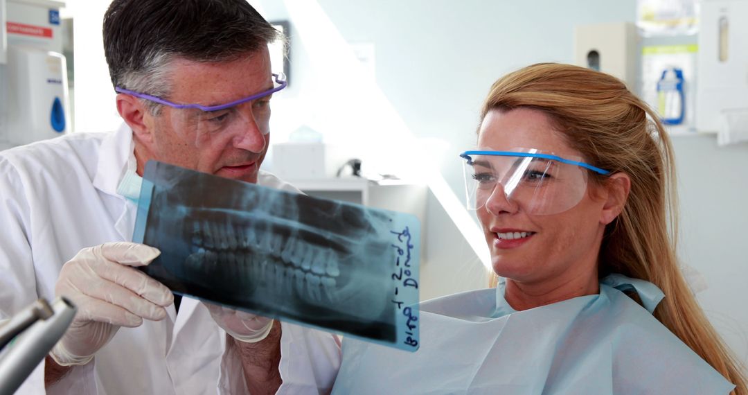 Dentist Showing Dental X-ray to Smiling Female Patient - Free Images, Stock Photos and Pictures on Pikwizard.com