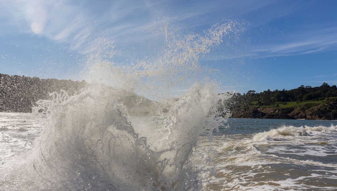 Dynamic Ocean Wave Crashing Against Rocky Shoreline