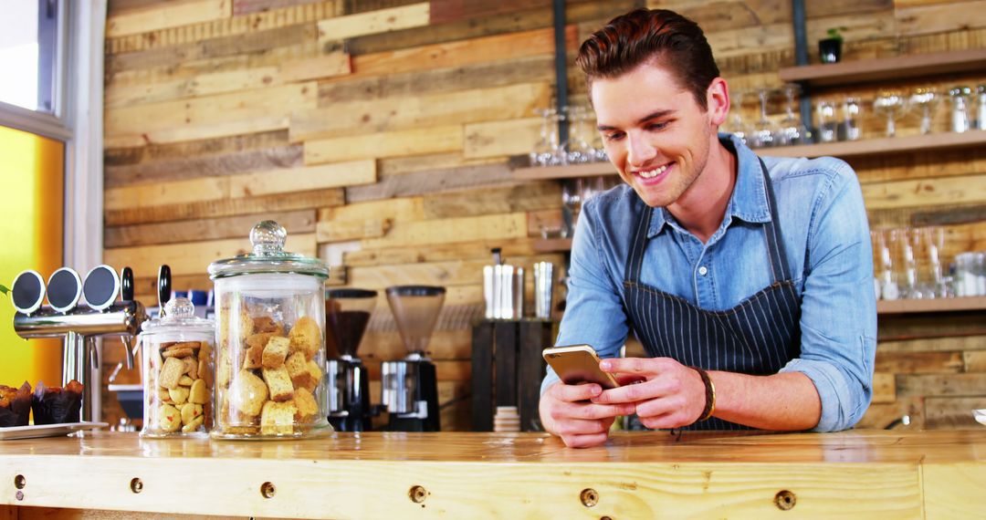 Smiling Barista Checking Phone in Rustic Café - Free Images, Stock Photos and Pictures on Pikwizard.com