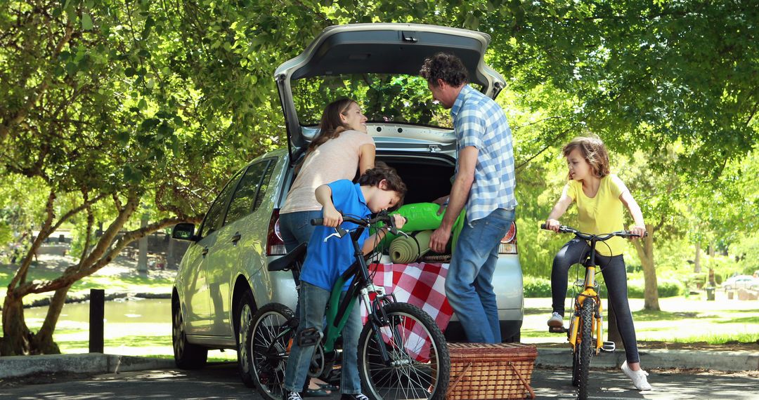 Family embarking on road trip adventure loading car with bicycles and picnic essentials - Free Images, Stock Photos and Pictures on Pikwizard.com