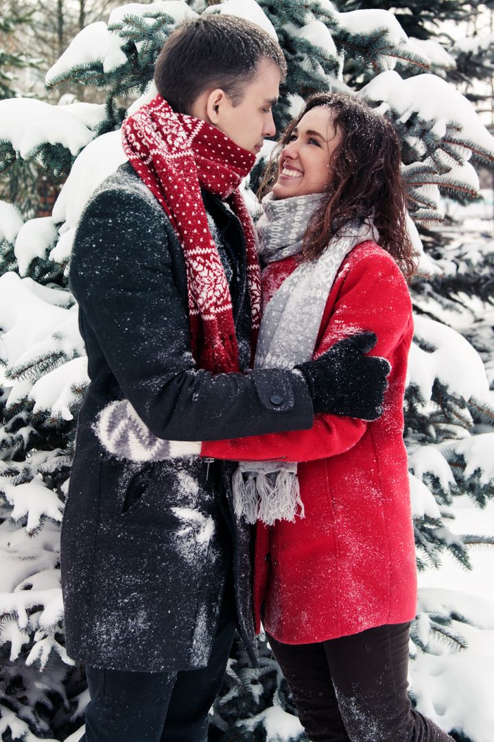 Couple Embracing in Snowy Winter Forest Wearing Warm Clothing - Free Images, Stock Photos and Pictures on Pikwizard.com