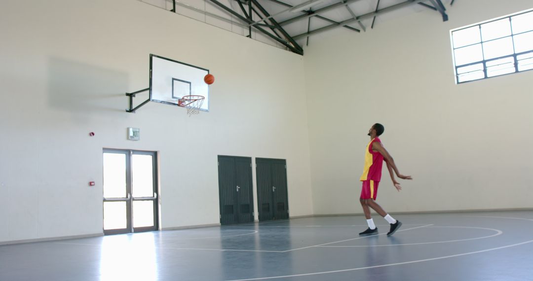 Man Practicing Basketball Shooting in Indoor Court