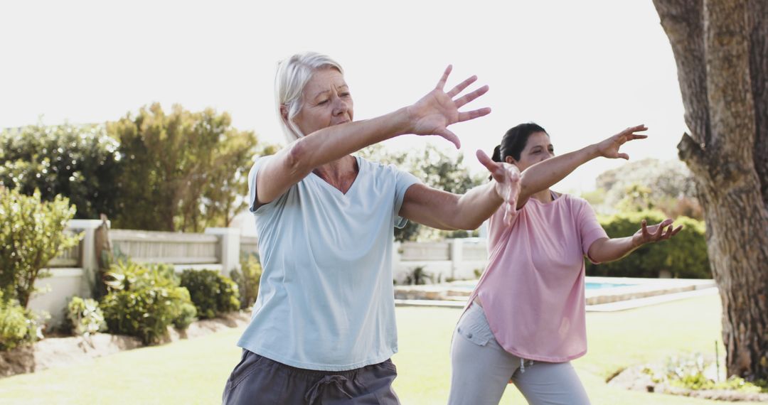 Senior Woman Practicing Tai Chi with Instructor in Garden - Free Images, Stock Photos and Pictures on Pikwizard.com