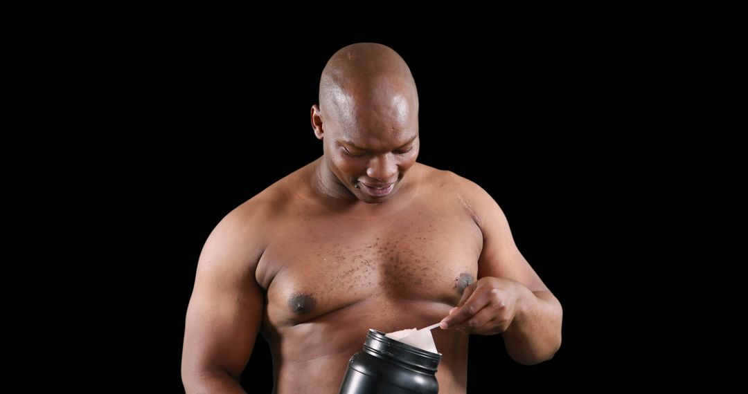 Muscular Man Preparing Protein Powder against Black Background - Free Images, Stock Photos and Pictures on Pikwizard.com