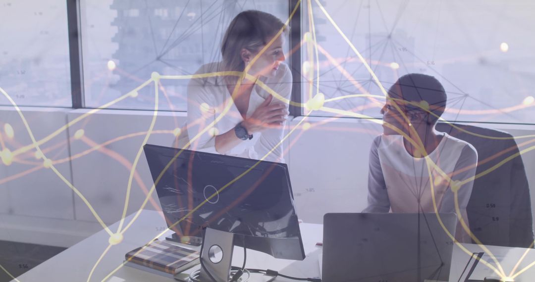 Businesswomen Discussing Data Analysis in Modern Office Environment