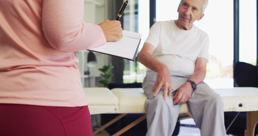 Elderly Man in Physical Therapy Session with Therapist Noting Progress - Free Images, Stock Photos and Pictures on Pikwizard.com