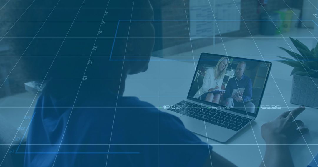 Woman watching remote presentation on laptop while leaning over desk in modern workspace