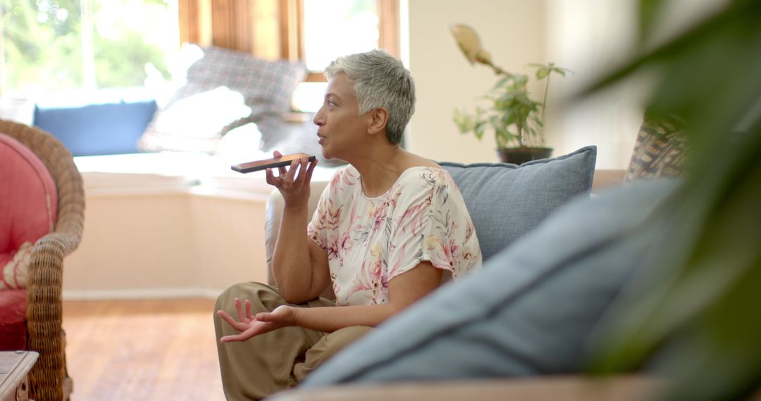 Senior Woman Relaxed Using Smartphone Voice Assistant at Home