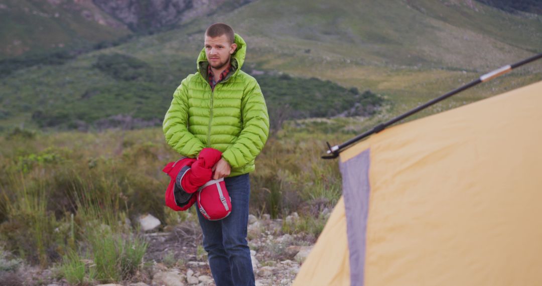 Camper Holding Sleeping Bag Near Tent in Mountainous Area - Free Images, Stock Photos and Pictures on Pikwizard.com