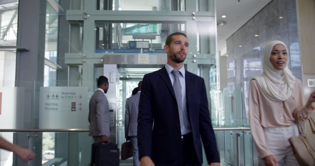 Diverse Business Team Exiting Elevator in Modern Office