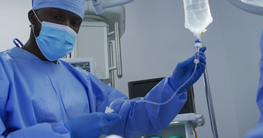 African American Surgeon Preparing IV Line in Operating Room - Free Images, Stock Photos and Pictures on Pikwizard.com