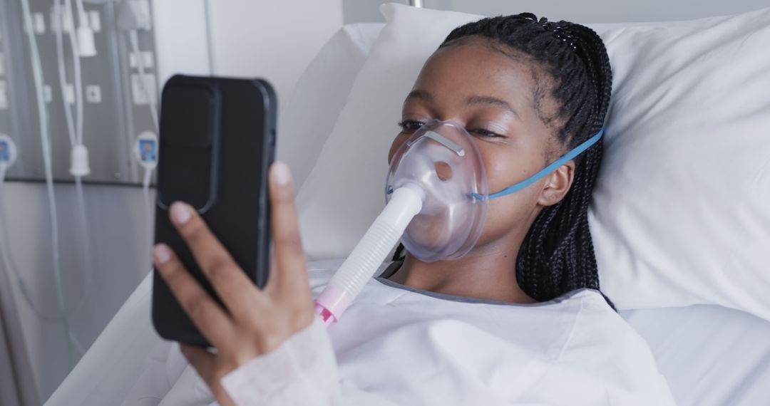 Young African American Woman Using Phone in Hospital Bed with Oxygen Mask - Free Images, Stock Photos and Pictures on Pikwizard.com