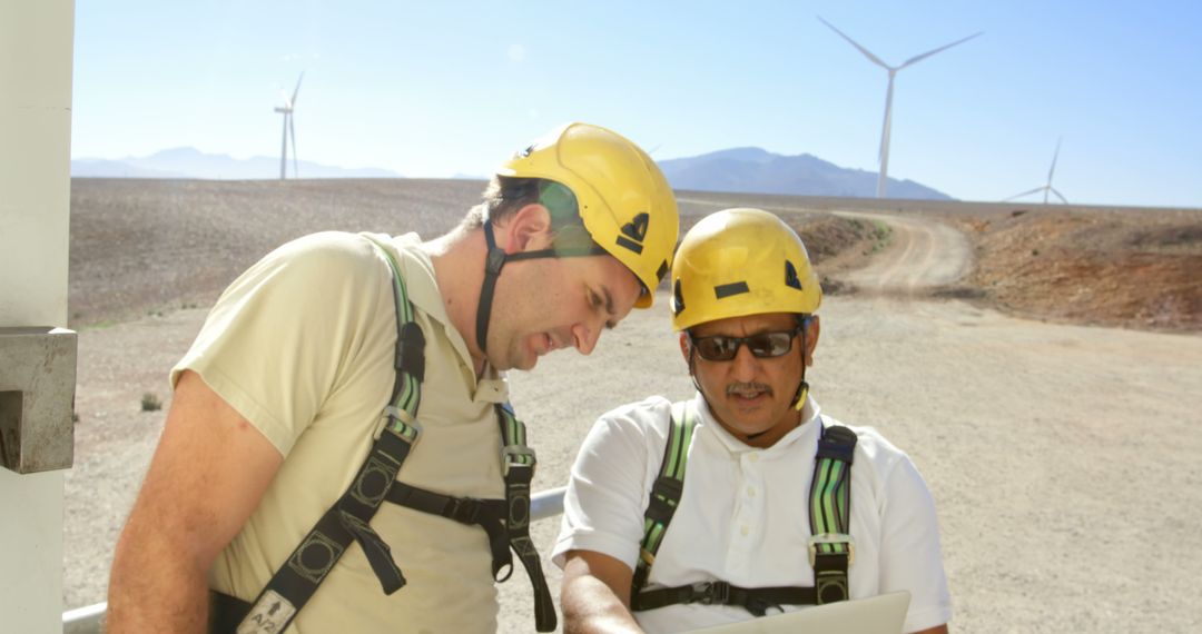 Engineers Collaborating at Wind Farm with Laptops Outdoors - Free Images, Stock Photos and Pictures on Pikwizard.com