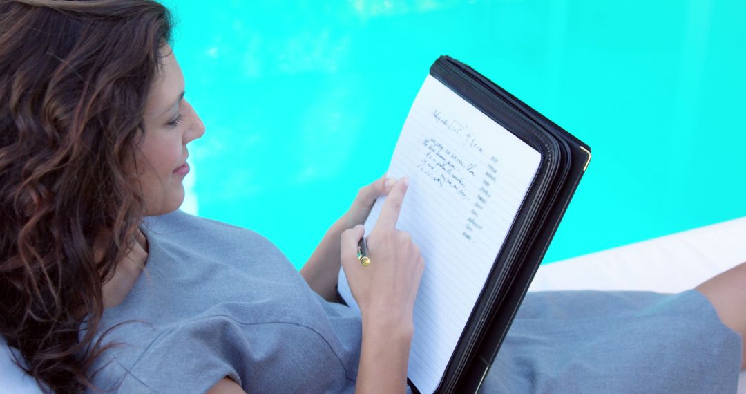 Woman Writing Notes Relaxing Poolside in Summer - Free Images, Stock Photos and Pictures on Pikwizard.com