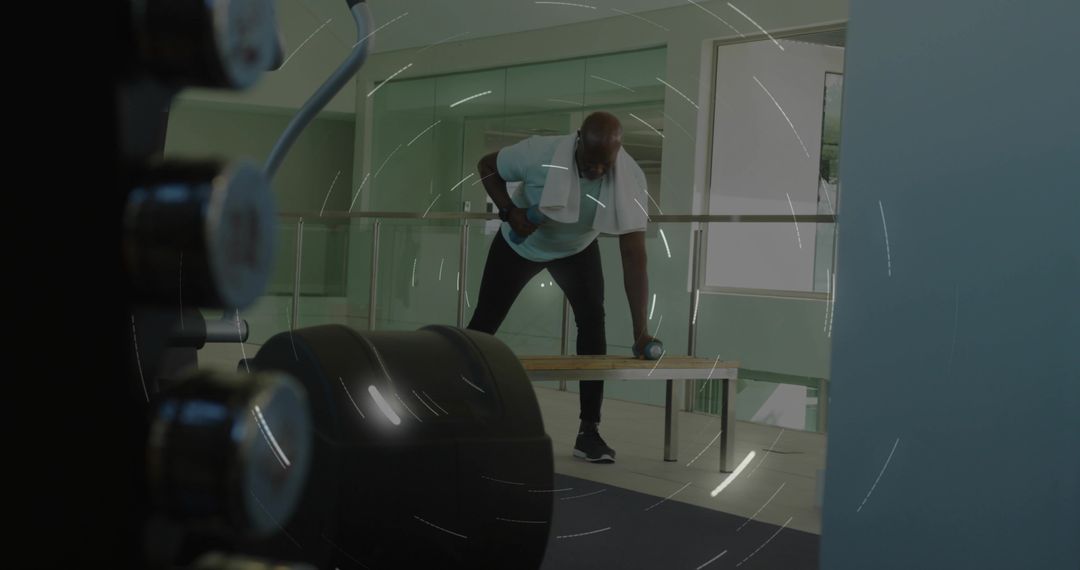 Performing One-Arm Dumbbell Row on Bench in Modern Gym with Towel and Focused Form