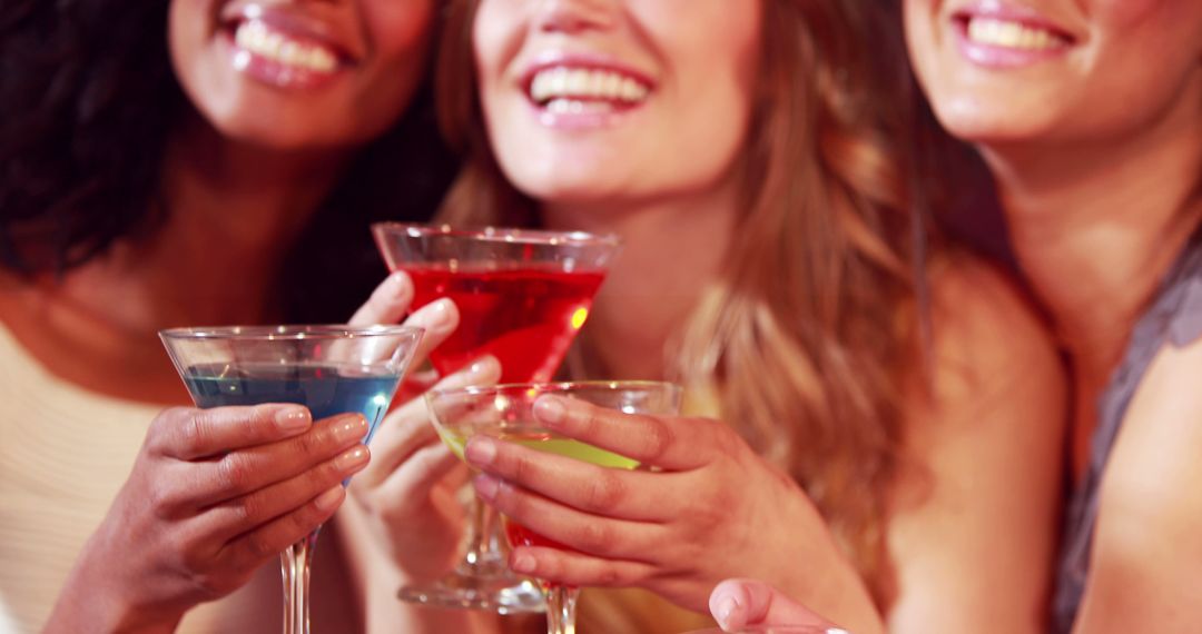 Close-Up of Smiling Women Toasting with Colorful Cocktails - Free Images, Stock Photos and Pictures on Pikwizard.com