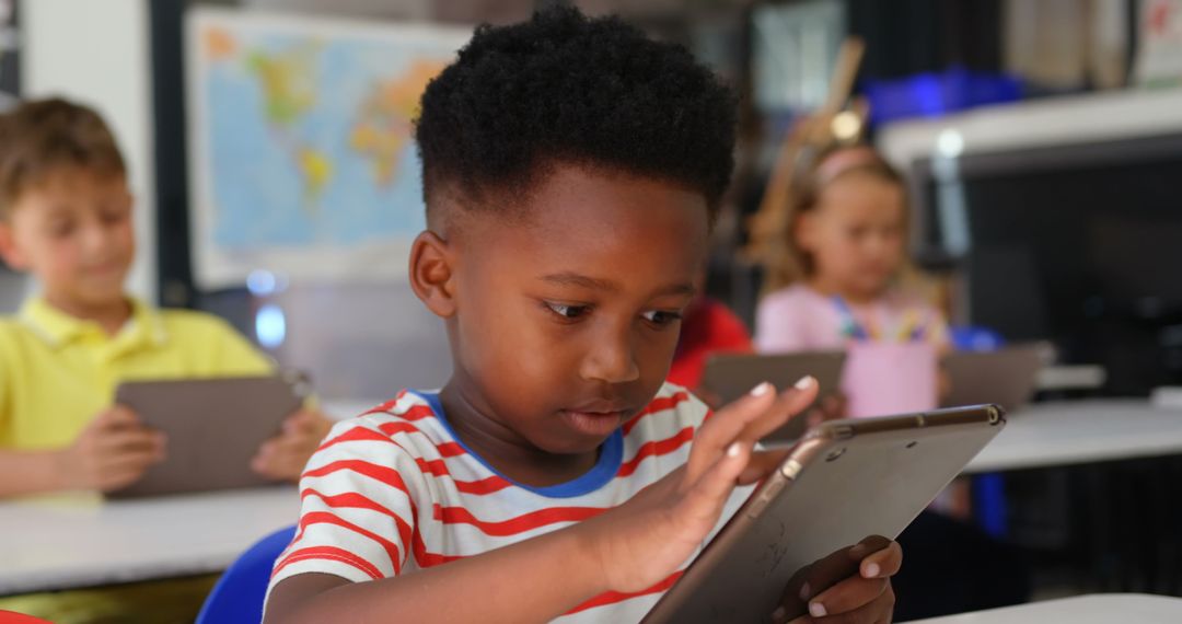 Focused African American Boy Using Tablet in Classroom