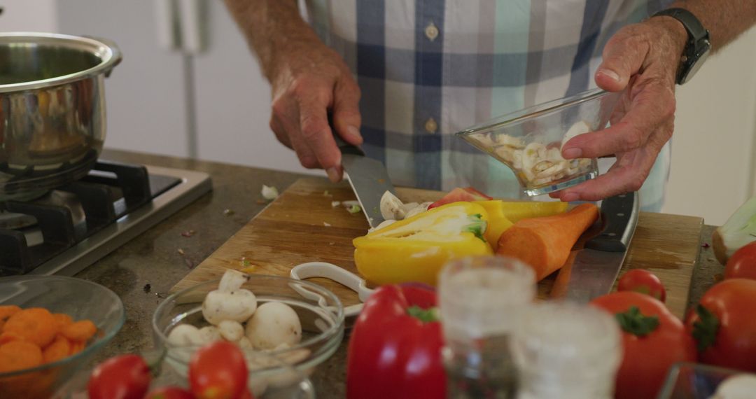 Senior Man Enthusiastically Preparing Fresh Vegetables in Kitchen - Free Images, Stock Photos and Pictures on Pikwizard.com