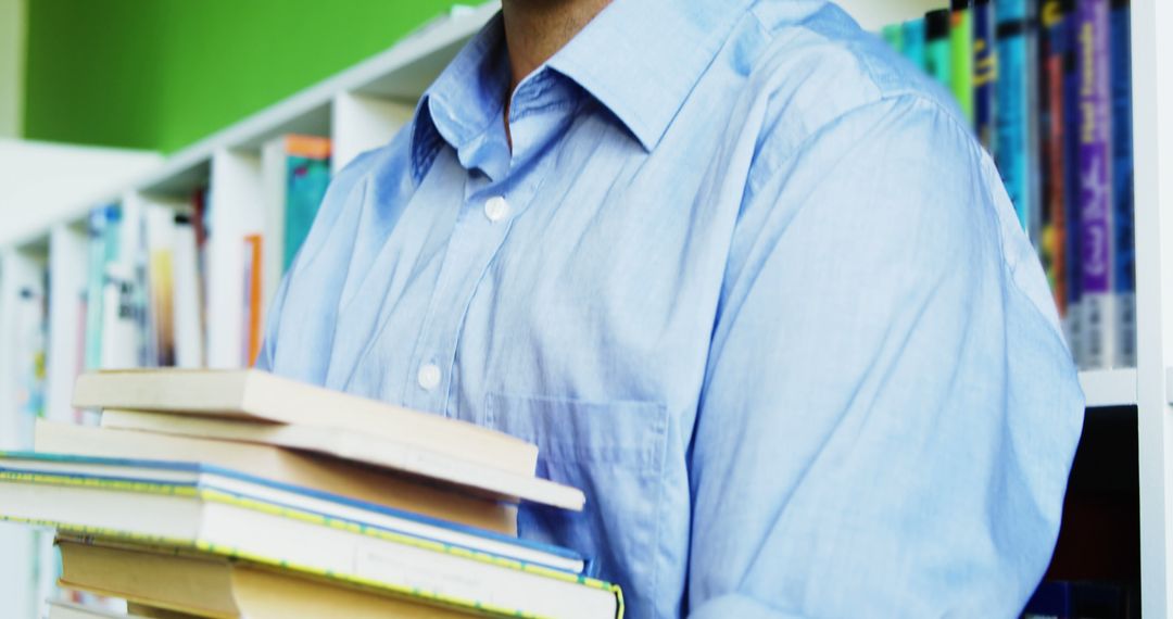 Person Holding Stack of Books in Library - Free Images, Stock Photos and Pictures on Pikwizard.com