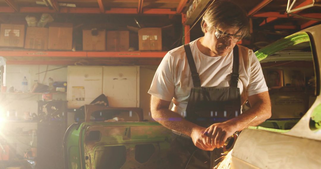 Mechanic Precision Grinding Car in Workshop with Goggles