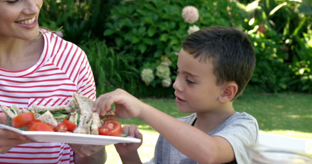 Mother and son enjoying outdoor picnic with healthy sandwiches - Free Images, Stock Photos and Pictures on Pikwizard.com