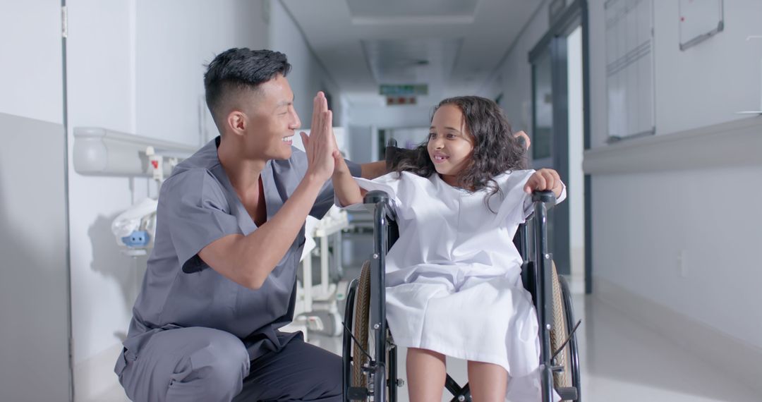 Smiling Nurse High-Fiving Young Girl in Wheelchair in Hospital - Free Images, Stock Photos and Pictures on Pikwizard.com