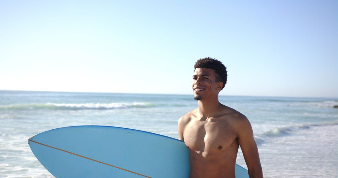 Young Man Smiling with Surfboard on Sunny Beach