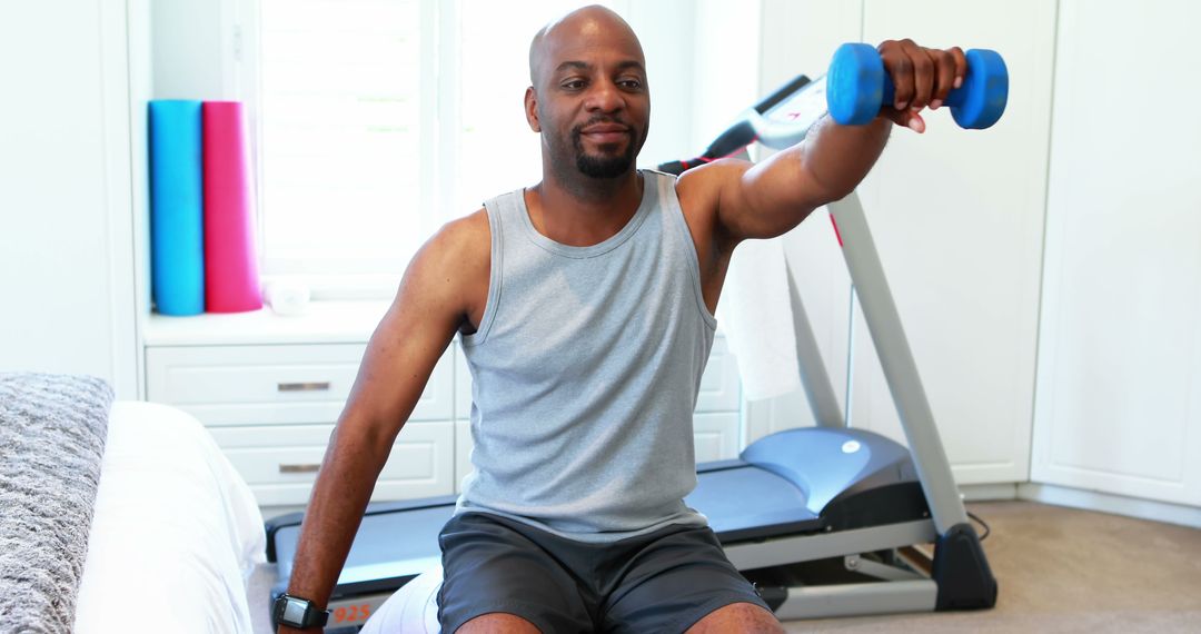 Active man in home gym lifting dumbbell during workout - Free Images, Stock Photos and Pictures on Pikwizard.com