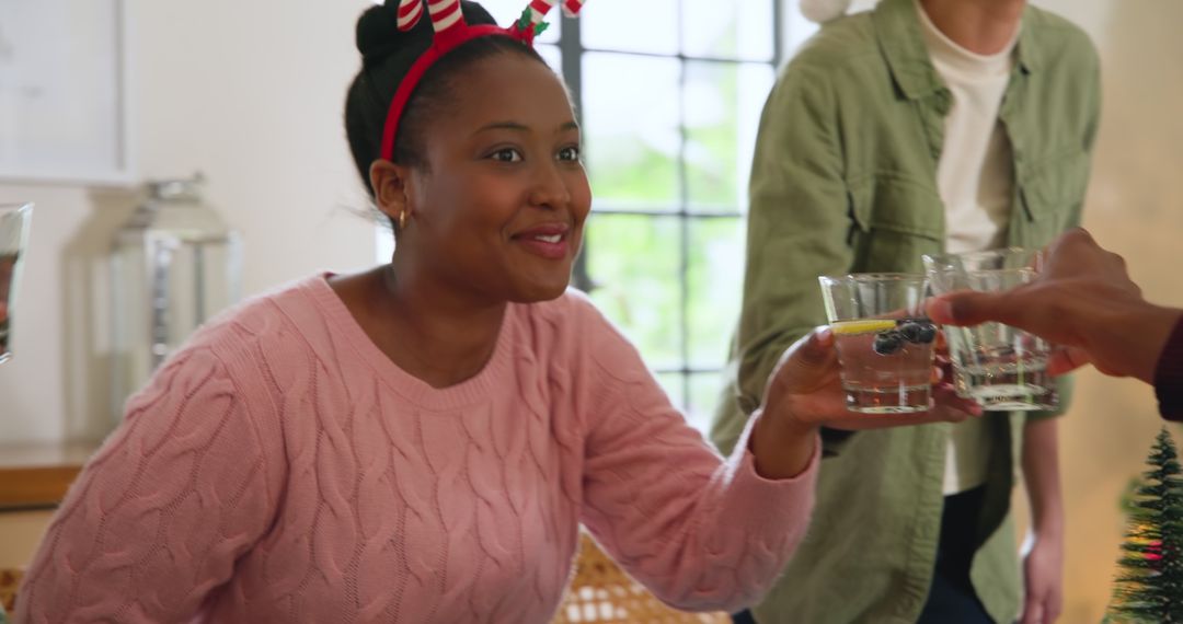 Festive Woman with Antler Headband Toasting by Christmas Tree