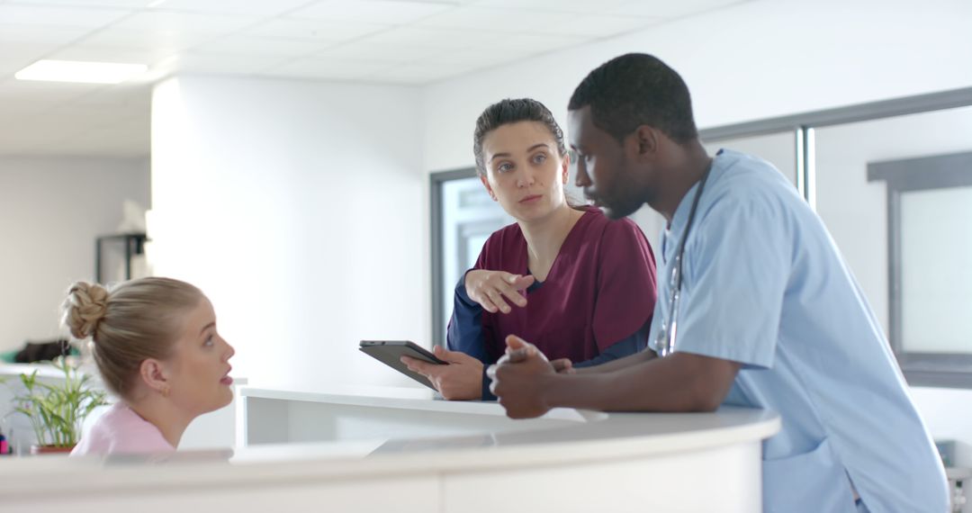 Diverse Medical Team Discussing at Reception Desk in Hospital - Free Images, Stock Photos and Pictures on Pikwizard.com