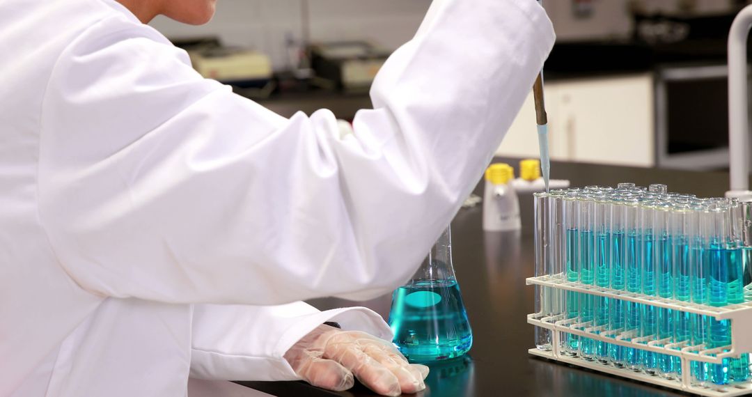 Scientist Conducting Experiment with Blue Chemicals in Laboratory - Free Images, Stock Photos and Pictures on Pikwizard.com