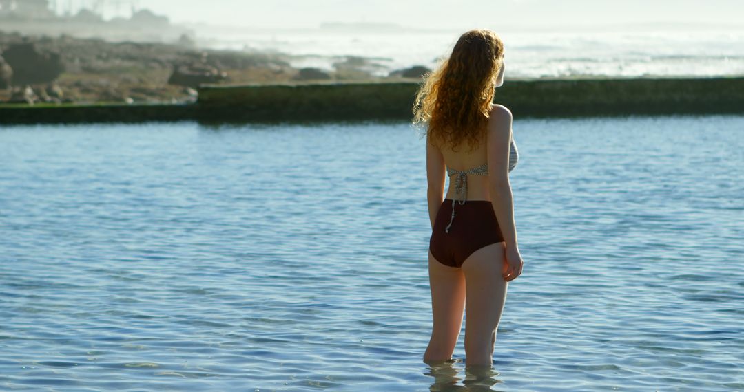 Woman in a Swimsuit Enjoying Ocean Water on a Sunny Day - Free Images, Stock Photos and Pictures on Pikwizard.com