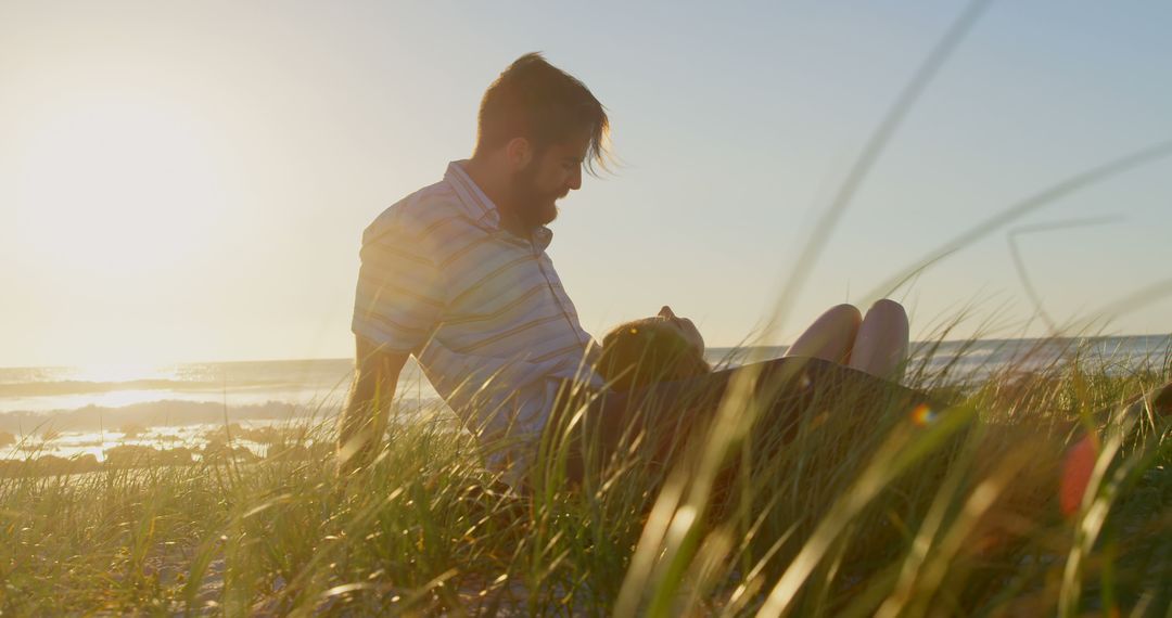 Couple Relaxing on Grassy Beach During Sunset - Free Images, Stock Photos and Pictures on Pikwizard.com