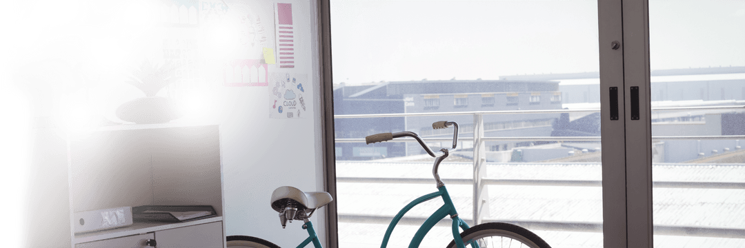 Bicycle Resting by Glass Window in Creative Modern Office