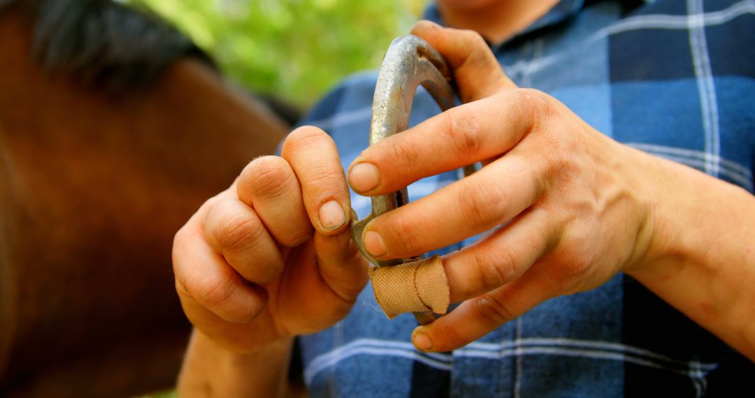 Farrier Preparing Horseshoe with Bandaged Finger - Free Images, Stock Photos and Pictures on Pikwizard.com