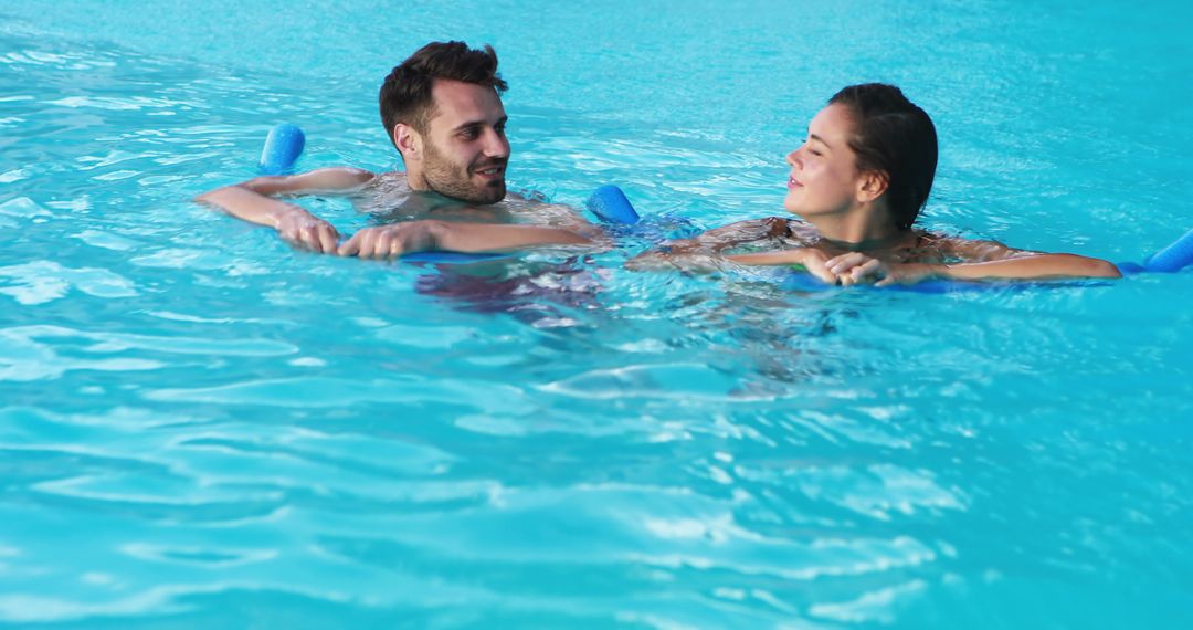 Happy Couple Relaxing on Pool Floats in Blue Swimming Pool - Free Images, Stock Photos and Pictures on Pikwizard.com