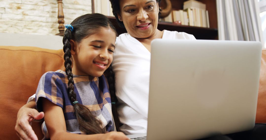 Smiling Girl and Grandmother Using Laptop Together at Home - Free Images, Stock Photos and Pictures on Pikwizard.com