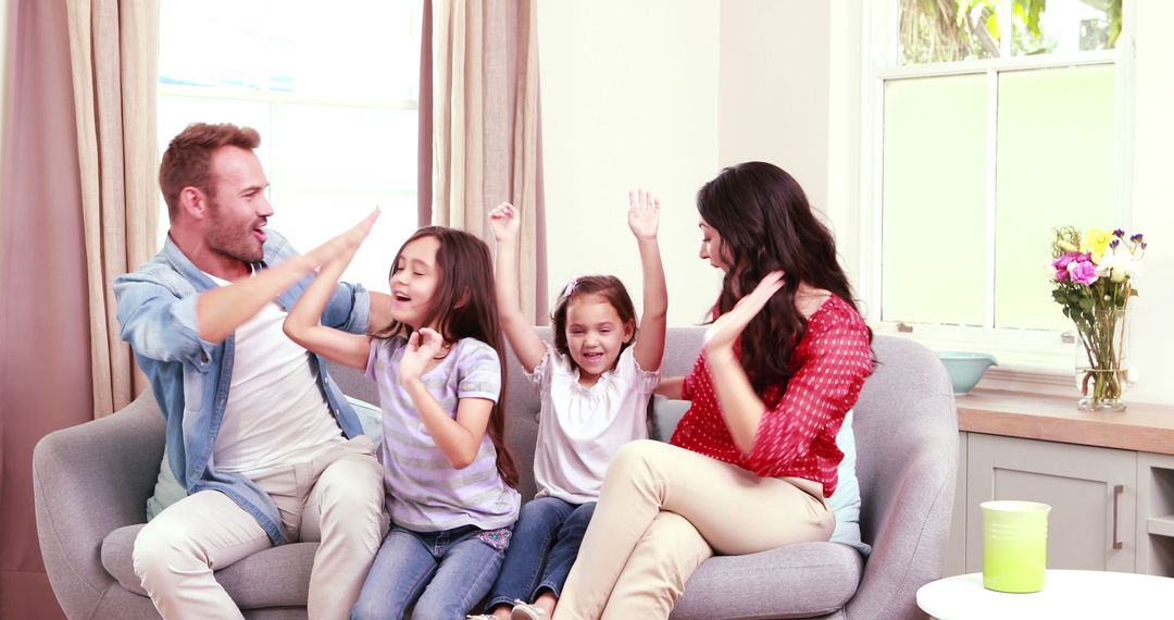 Joyful Family High Fiving Together in Bright Living Room - Free Images, Stock Photos and Pictures on Pikwizard.com