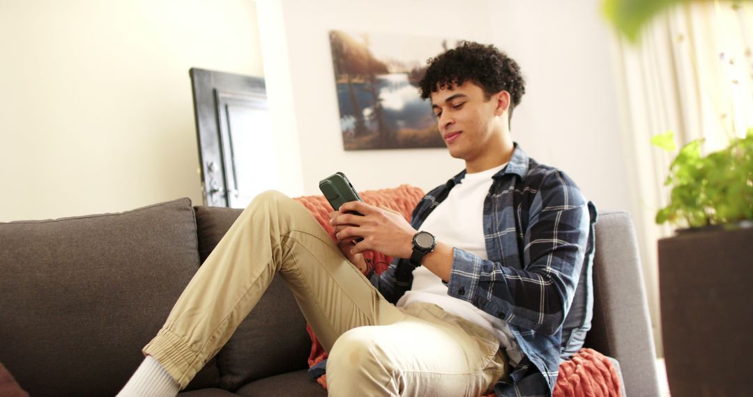 Young Man Relaxing on Couch Using Smartphone - Free Images, Stock Photos and Pictures on Pikwizard.com