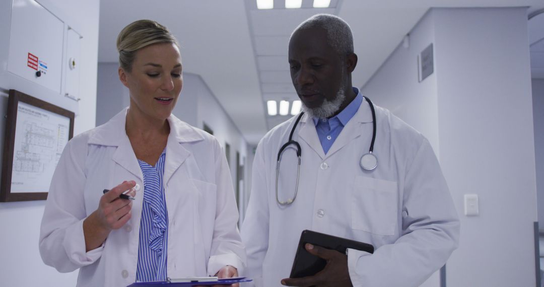 Medical Professionals Discussing Work in Hospital Corridor - Free Images, Stock Photos and Pictures on Pikwizard.com