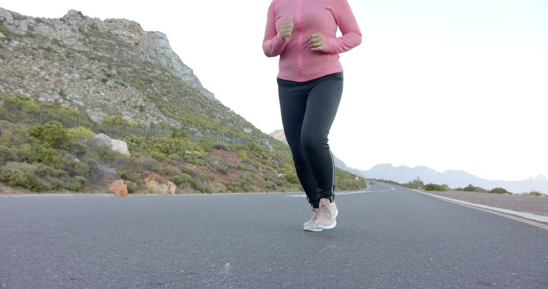 Woman jogging on mountain road, embracing outdoor fitness