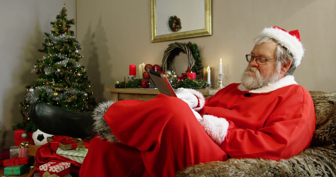 Santa Claus Relaxing at Home with Digital Device During Christmas - Free Images, Stock Photos and Pictures on Pikwizard.com