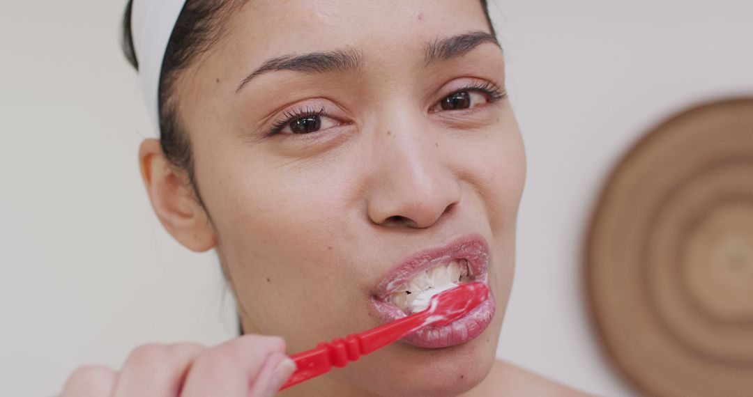 Portrait of biracial woman brushing teeth in bathroom - Free Images, Stock Photos and Pictures on Pikwizard.com